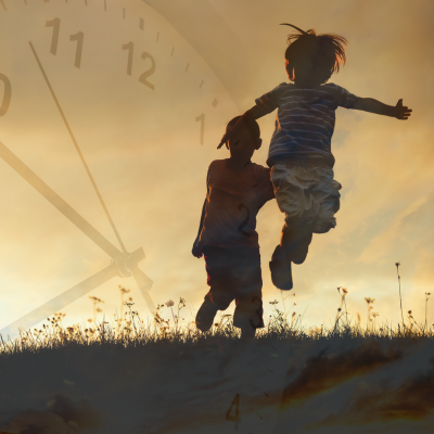 Photo de deux enfants à contre-jour courant dans une prairie