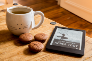Tasse de thé, petits gateaux et liseuses numérique sur une table