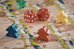 Une paire de dés et trois pions bleu, rouge et jaune sur un plateau de jeu