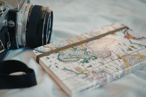 Photo d'un appareil photo et d'un carnet avec un planisphère en couverture