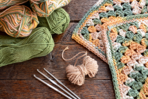 Photo de pelotes de fils, de carrés crochetés et de crochets