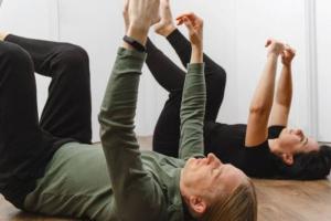 Deux personnes allongées sur le dos faisant des exercices d'assouplissement