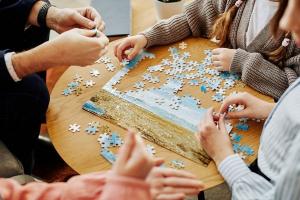 Photo de personnes autour d'une table entrain de jouer à un puzzle